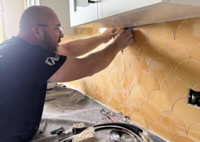Alicatando paredes cocina con azulejos de formato de escama de pez